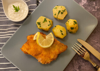 Breaded pike perch fillets with parsley potatoes and sauce tartar.