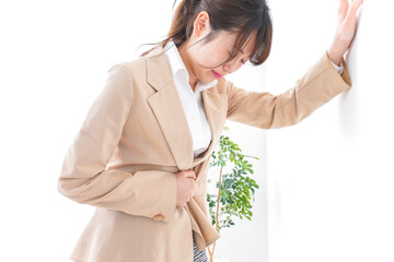 腹痛で苦しむビジネスウーマン