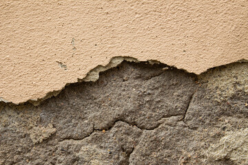 Old dirty weathered wall with layers of plaster falling off ready for repair