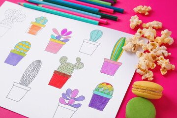Coloring picture, macaroons and pencils on table, closeup