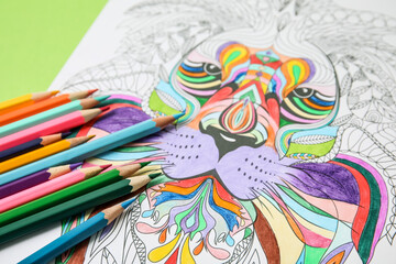 Coloring picture and pencils on table, closeup