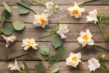Beautiful flowers and branches on wooden background