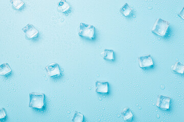 Top view photo of scattered melting ice cubes and water drops on isolated light blue background