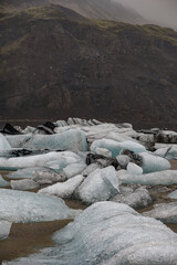 The Solheimajokull Glacier in Iceland showing icebergs and calved ice in the lagoon as ice calves...