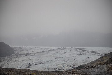 The Solheimajokull Glacier in Iceland showing icebergs and calved ice in the lagoon as ice calves...