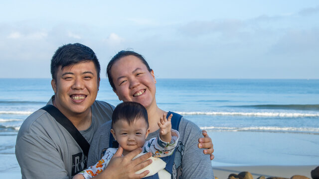 A happy Asian Chinese family group photo on tropical beach