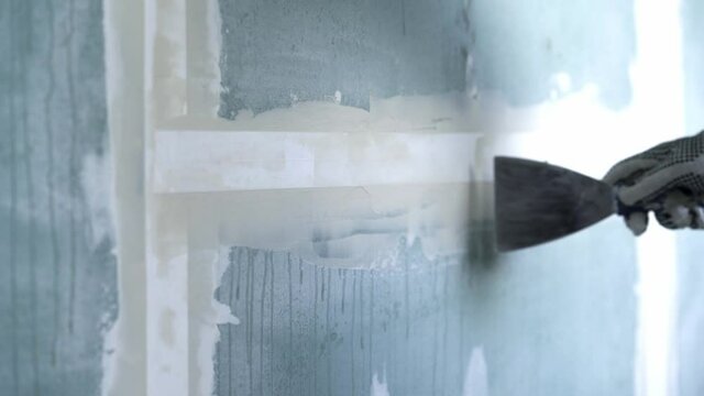 Worker Glues Plasterboard Joint