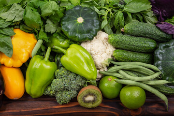 Assorted of fresh vegetables. Colorful summer vegetable frame. Variety of raw green vegetables as frame over dark wooden texture background.Healthy organic vegetables on a rustic wooden background.