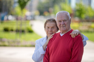 Senior adults walking in a park holding hands	