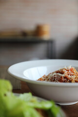 spaghetti Bolognese with italian sausage and tomato sauce with parmesan cheese and basil