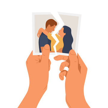 Hands holding a torn photo of a couple in love. The concept of divorce, separation and broken heart