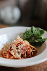 spaghetti Bolognese with italian sausage and tomato sauce with parmesan cheese and basil