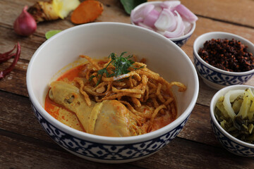 Local northern Thai food Egg noodle curry with chicken on wood background