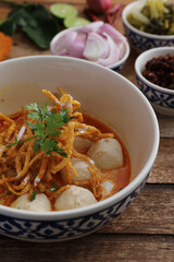 Local northern Thai food Egg noodle curry with meatballs on wood background