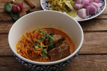 Local northern Thai food Egg noodle curry with pork ribs on wood background