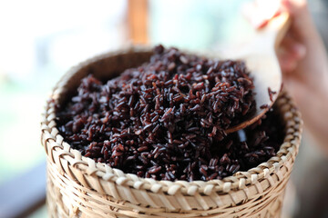 Boiled riceberry rice on wood basket with spoon in close up