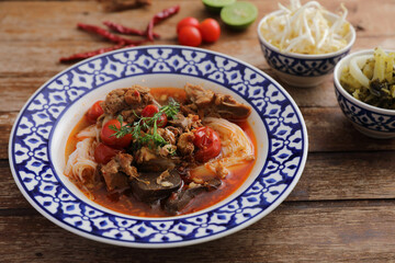 Local northern thai food Rice noodles with pork in spicy soup in wood background