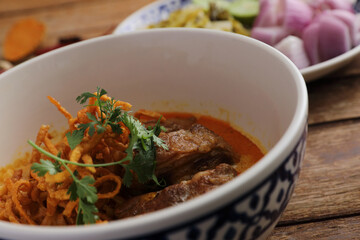 Local northern Thai food Egg noodle curry with pork ribs on wood background