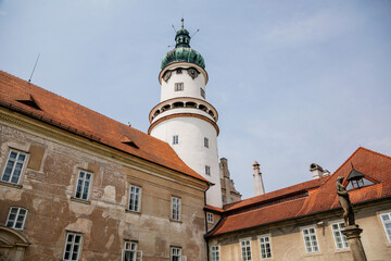 Fototapeta premium Baroque romantic castle Nove mesto nad Metuji with park, renaissance chateau, round white clock tower, red tile roof, Italian garden, summer sunny day, Eastern Bohemia, Czech Republic