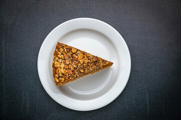 Honey cake on a white plate and a dark table
