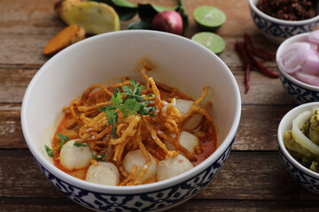 Local northern Thai food Egg noodle curry with meatballs on wood background
