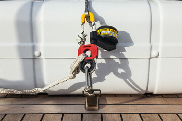 Life raft in capsules are fixed on the teak deck of the yacht in close-up. Mechanism for fastening...
