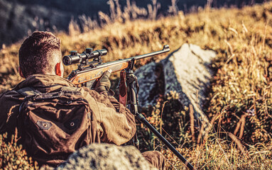Hunter is aiming. Shooter sighting in the target. The man is on the hunt. Hunt hunting rifle....