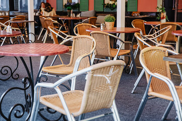 Cozy outdoor cafe in the open air. Wicker chairs and tables in an empty open-air restaurant. Calm and romantic place for meetings, dates. Retro design