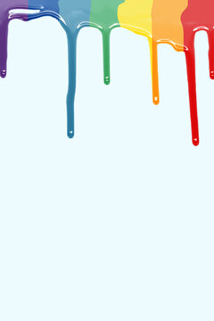 Drops of paint falling as LGBT flag in a blue background. paint rainbow. vertical image with copy space.
