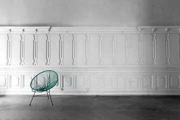 Green Vintage wire mesh chair in empty room with stucco elements wall background. Living room with antique stylish green chair on white wall design bas-relief stucco mouldings roccoco elements 