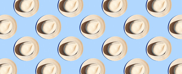 Pattern of straw hats on blue pastel background