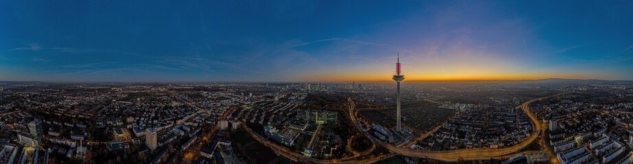 Panoramic drone image of the Frankfurt skyline with television tower in the evening during a colorful and impressive sunset