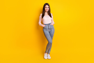 Fototapeta na wymiar Full size photo of happy positive smiling beautiful gorgeous woman hold hands pockets isolated on yellow color background