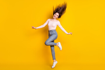 Fototapeta na wymiar Full size photo of young happy excited smiling crazy funky girl jumping with flying hair isolated on yellow color background