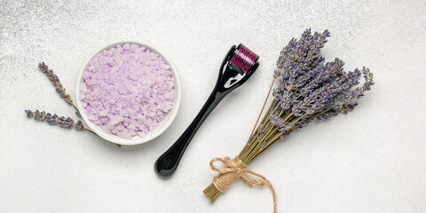 Lavender cosmetics  background. Sea bath salt, face derma roller and flowers. Aromatherapy, spa....