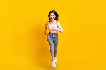 Fototapeta na wymiar Full size photo of young happy excited beautiful charming girl running fast speed in air isolated on yellow color background