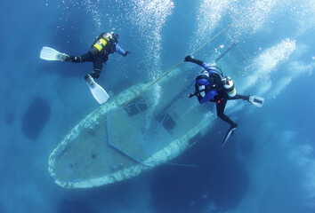Scuba Divers go down the rope and Exploring underwater ship wreck 