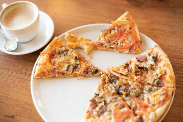 Eaten pizza with mushrooms on a round white plate