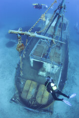 Scuba Divers Exploring underwater ship wreck. Variable focus. 