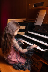 Little girl playing a pipe organ