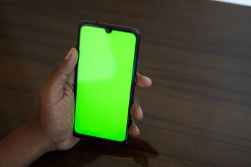Closeup shot of hand using mobile phone with Green screen, Finger swiping up and down in green screen of the mobile. Green screen mockup template of Mobile phone, Chroma key	