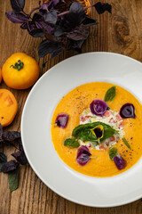 Tomato puree soup with yellow tomatoes on a wooden table
