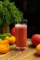 Tomato juice, on a children's table, near the green and yellow and red tomatoes
