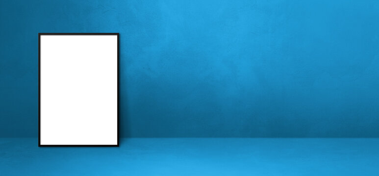 Black picture frame leaning on a blue wall. Horizontal banner