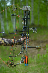 professional archer shooting with modern longbow at forest 