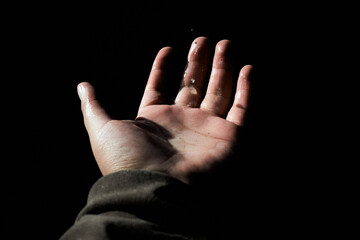 Hand hanging in the air with a few drops