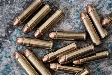 Brass handgun ammunition against a wooden backdrop