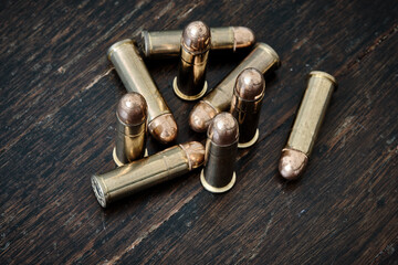 Obraz premium Brass handgun ammunition against a wooden backdrop