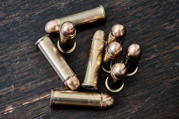 Obraz na płótnie Canvas Brass handgun ammunition against a wooden backdrop
