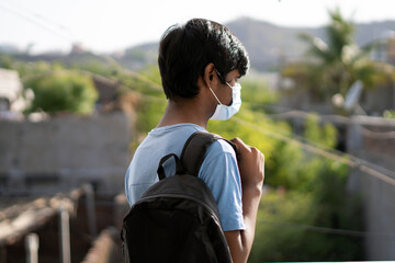 Portrait of an Indian kid wearing mask going to school, New normal in schools	
